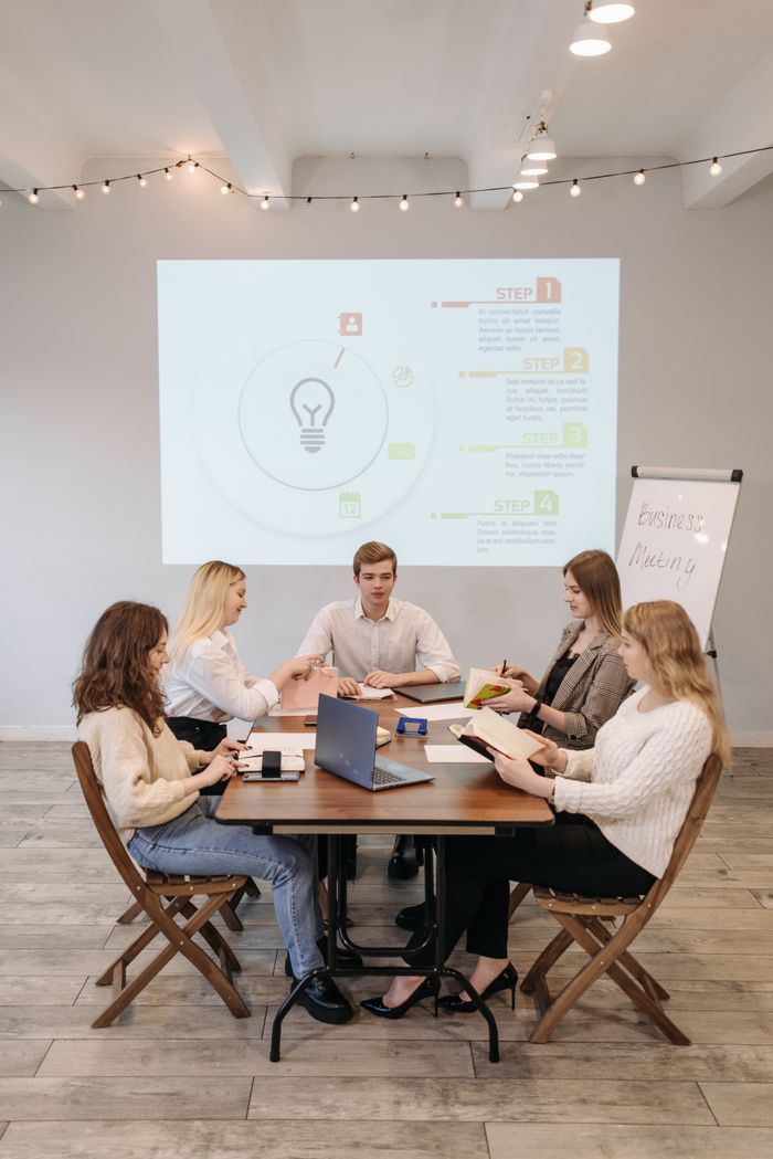 The Art of Drawing Readers In: Your attractive post title goes here Business team collaborates during a presentation in a well-lit office setting.